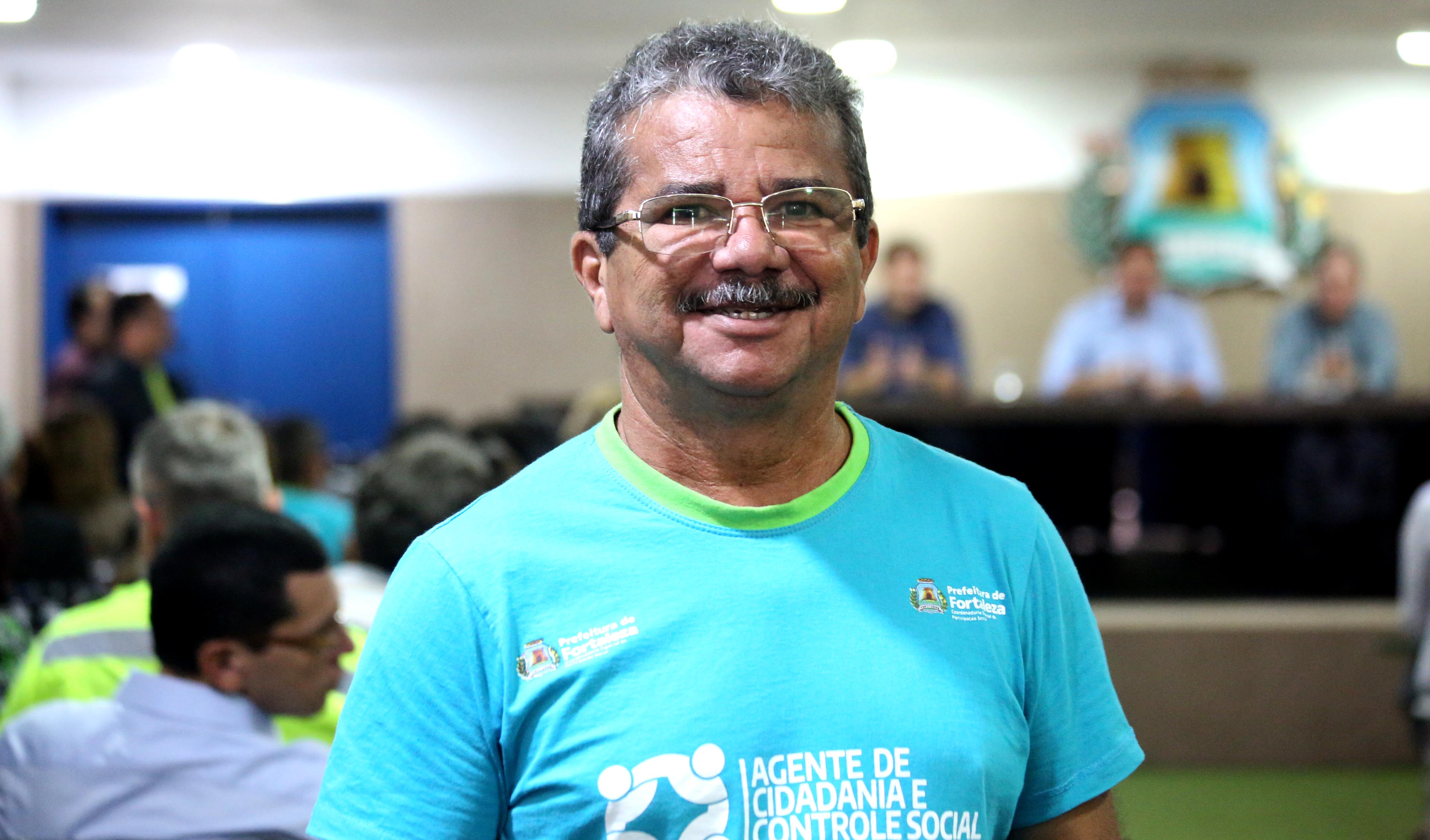 homem de óculos sorrindo para a foto